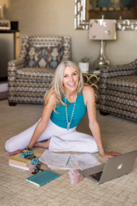 cynthia delaney sitting down with her crystals, astrology charts and laptop