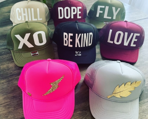 A display of trucker hats in a variety of colors, showcasing different styles and designs.