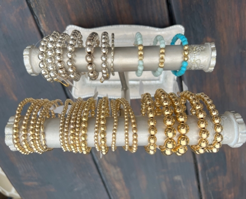 Gold and silver bracelets by Jeweled Fate displayed together, showcasing intricate designs and elegant craftsmanship